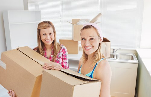 Local movers handling packed office equipment during a business relocation